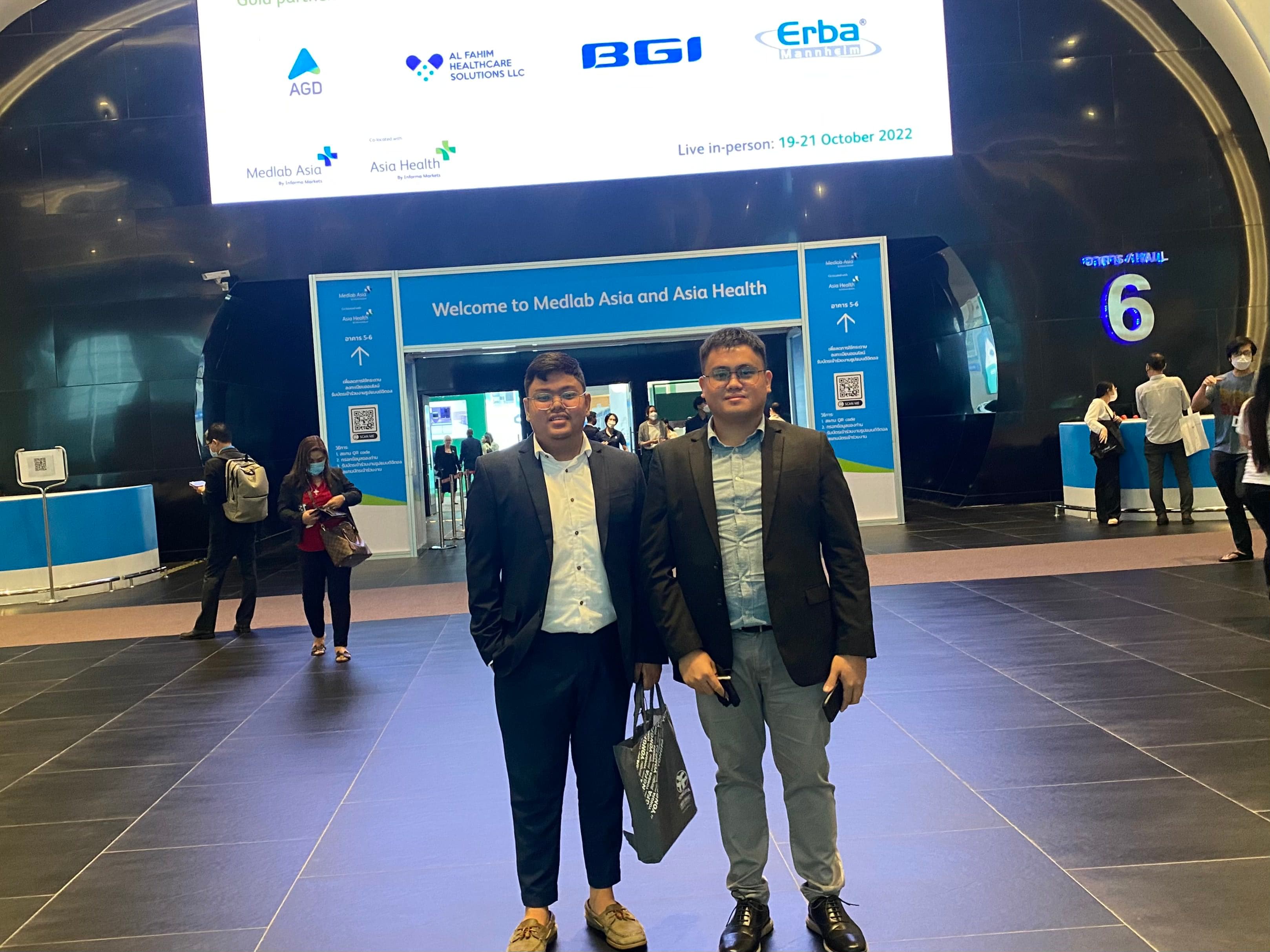 Two delegates in suits at the entrance hall of the MedLab Asia trade event in Bangkok