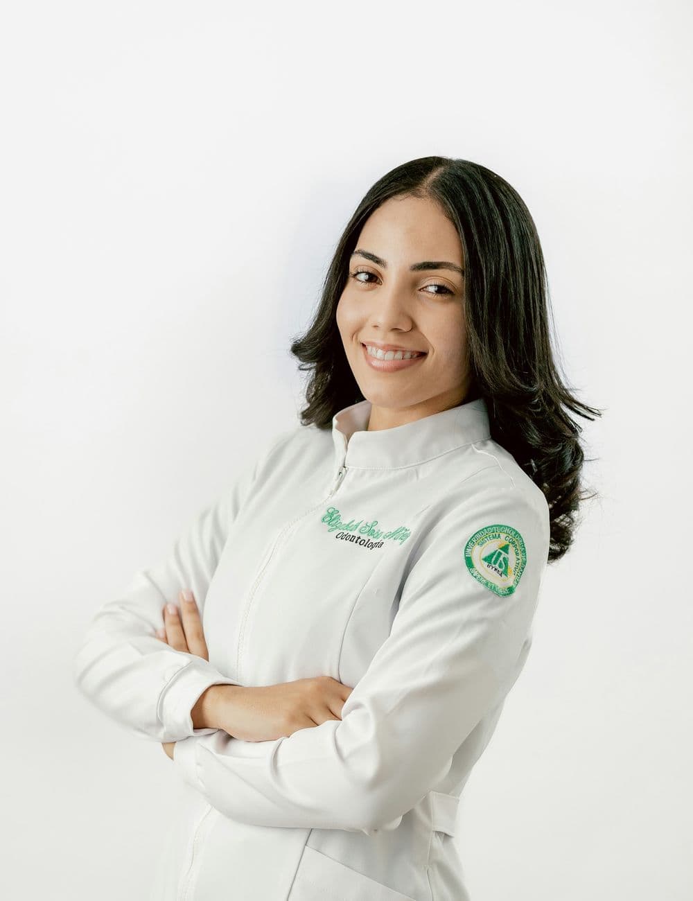 Smiling healthcare professional in a white lab coat with arms crossed
